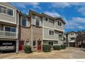 Townhome exterior showing brick accents, red doors, and garage access; greenery adds to the landscape at 4947 Noble Park Pl, Boulder, CO 80301