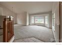 Bright living room with neutral carpet, large windows, and a vaulted ceiling at 678 Mcclure Ct, Erie, CO 80516