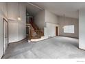 Spacious living room featuring vaulted ceilings, a staircase, and neutral carpet at 678 Mcclure Ct, Erie, CO 80516