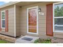 Welcoming front door with glass panel, accented by red shutters and a tidy, landscaped entryway at 852 W Linden St, Louisville, CO 80027