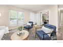 Bright living room featuring hardwood floors, a large window, and modern blue armchairs at 852 W Linden St, Louisville, CO 80027