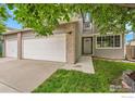 Home with a two-car garage, well-maintained lawn, and a welcoming front entrance at 11740 Ivy St, Thornton, CO 80233