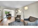 Cozy living room with hardwood floors, stylish armchairs, and an open view to the dining area at 11740 Ivy St, Thornton, CO 80233