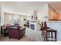 Bright living room featuring a fireplace, carpeted flooring and multiple windows that provide plenty of natural light at 122 Whitehaven Cir, Highlands Ranch, CO 80129