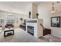 A cozy living room boasting a tiled fireplace, carpeted flooring, and large windows for natural light at 122 Whitehaven Cir, Highlands Ranch, CO 80129