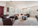 Bright living room with plush carpet, neutral walls, and multiple windows for abundant natural light at 122 Whitehaven Cir, Highlands Ranch, CO 80129
