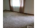 Cozy bedroom featuring plush carpet, bright window, and neutral decor at 1918 Sumac Pl, Longmont, CO 80501