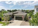 A well-maintained home with a two-car garage, manicured landscaping, and a cozy front porch with a blue chair at 24725 E Dry Creek Pl, Aurora, CO 80016