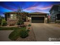 Charming home with stone accents, a two-car garage, landscaped front yard, and an American flag waving in front at 24725 E Dry Creek Pl, Aurora, CO 80016