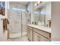 Modern bathroom featuring a glass-enclosed shower with marble tiles and dual vanity sinks at 2739 Crystal Springs Ln, Longmont, CO 80503