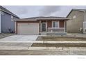 Charming single-story home featuring a garage, a front porch with white railings, and low-maintenance gravel landscaping at 2739 Crystal Springs Ln, Longmont, CO 80503