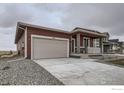 Single-story home showcasing a two-car garage, covered front porch, and low-maintenance rock landscaping at 2739 Crystal Springs Ln, Longmont, CO 80503