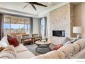 Inviting living room with a stone fireplace, large windows, and comfortable seating area at 2739 Crystal Springs Ln, Longmont, CO 80503