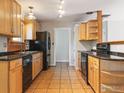 A functional kitchen featuring wood cabinets, black appliances, and tile flooring at 2901 Lorraine Ct, Boulder, CO 80304