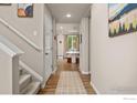 Bright entryway with hardwood floors, staircase, and views of the dining area at 3326 Dryden Pl, Mead, CO 80542