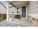 Inviting front porch with stone accents, bench seating, and a wreath on the door at 3326 Dryden Pl, Mead, CO 80542