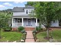 Inviting two-story home with a covered front porch, stone walkway, and lush garden landscaping at 3561 4Th St, Boulder, CO 80304