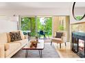 Bright living room features a cozy sofa, modern fireplace, and sliding glass doors to the outdoor patio at 3805 Northbrook Dr # A, Boulder, CO 80304