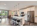 Modern kitchen with island, pendant lighting, stainless appliances, and hardwood floors at 4343 E 96Th Way, Thornton, CO 80229