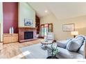 Bright living room featuring a brick fireplace, vaulted ceilings, and wood flooring at 5420 Crestone Cir, Boulder, CO 80301