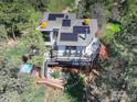 An aerial view shows the deck, hot tub, and solar panels adorning the roof of this house at 6310 Red Hill Rd, Boulder, CO 80302
