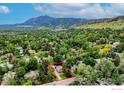 Aerial view of home nestled among lush trees with mountain views in the distance at 740 Hawthorn Ave, Boulder, CO 80304