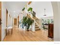 Bright and airy foyer featuring gleaming hardwood floors and an elegant staircase with wooden banister at 7760 Crestview Ln, Niwot, CO 80504