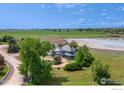 Aerial view of the house surrounded by trees, overlooking a peaceful lake at 7785 Darvey Ln, Longmont, CO 80504