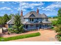Beautiful exterior of a two-story home with brick walkway, porch, and mountain views at 7785 Darvey Ln, Longmont, CO 80504