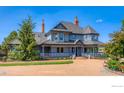 Charming two-story home features a spacious porch and well-manicured lawn at 7785 Darvey Ln, Longmont, CO 80504