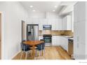 Bright kitchen features stainless steel appliances, hardwood floors, and white cabinets at 876 Cimarron Dr # B, Lafayette, CO 80026