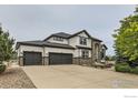 Spacious home with a three-car garage and concrete driveway, surrounded by mature trees at 8839 Shetland Dr, Frederick, CO 80504
