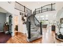 Grand foyer featuring a curved staircase, hardwood floors, and an open view to the living areas at 8839 Shetland Dr, Frederick, CO 80504