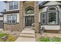 Close-up of the home's front entrance, emphasizing the stone archway and meticulously kept garden at 8839 Shetland Dr, Frederick, CO 80504