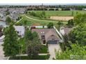 A bird's eye view of the home with a beautiful green space nearby with a path at 901 Welch Ave, Berthoud, CO 80513