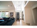 Bright foyer featuring soaring ceilings, a modern chandelier, and a dark-colored front door with sidelights at 9415 E 58Th Dr, Denver, CO 80238