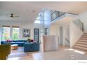 Bright, open-concept living room with a soaring ceiling and staircase at 9415 E 58Th Dr, Denver, CO 80238
