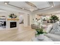 Bright living room with fireplace, light wood floors, and modern decor at 9527 Loveland Way, Arvada, CO 80007
