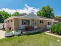 Inviting single-story home with a brick facade, front porch bench, and well-kept lawn at 10951 Rosalie Dr, Northglenn, CO 80233