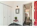 Entryway with slate flooring, coat closet, and decoratively framed mirror above a small table with houseplant at 1110 Poplar Ave, Boulder, CO 80304