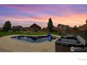 Backyard boasts an in-ground pool and spa, great for entertaining or relaxing under the evening sky at 13598 Horseshoe Cir, Mead, CO 80542