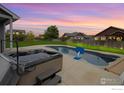 In-ground pool and hot tub in a backyard setting with string lights and lush greenery; a true oasis at 13598 Horseshoe Cir, Mead, CO 80542