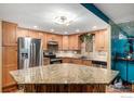 Spacious kitchen with granite counters, stainless steel appliances, and breakfast bar seating at 14000 E Linvale Pl # 210, Aurora, CO 80014