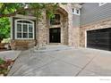 Elegant front entrance with stone archway and spacious concrete driveway at 14075 Willow Wood Ct, Broomfield, CO 80020