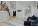 Bright living room with hardwood floors, staircase, and large window with lots of light at 14075 Willow Wood Ct, Broomfield, CO 80020