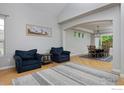 Open-concept living room with hardwood floors leading to a dining area at 14075 Willow Wood Ct, Broomfield, CO 80020