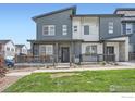 Charming townhome with a covered porch, stone accents, and manicured lawn at 14553 W 91St Dr # A, Arvada, CO 80005