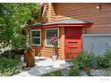 Close-up of the home's red front door with neat landscaping, and beautiful potted plants at 1484 Wicklow St, Boulder, CO 80303