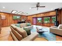 Spacious living room with wood paneled walls, modern furniture, and natural light at 1484 Wicklow St, Boulder, CO 80303