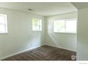 A bright bedroom with neutral walls, carpeted floors, and natural light from two windows at 15532 E Pacific Pl, Aurora, CO 80013